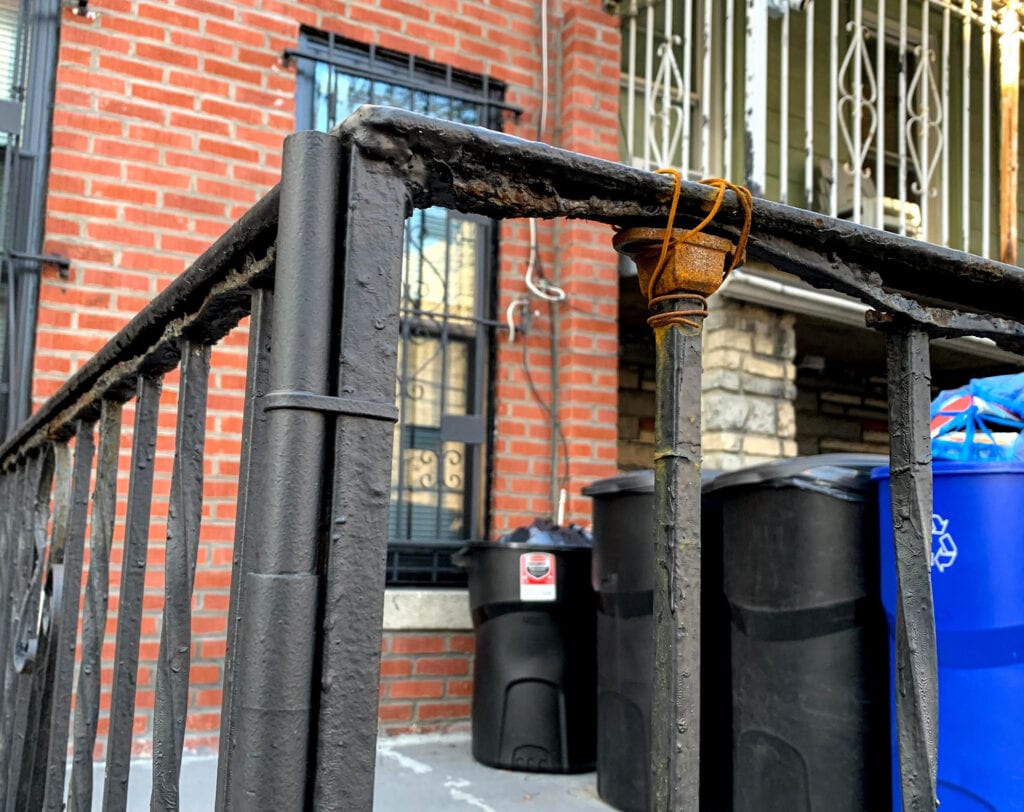 Several examples of severe rust on exterior wrought iron railing