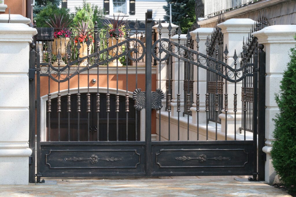 An example of a galvanized driveway gate with thick bottom solid plates, finished with patina paint